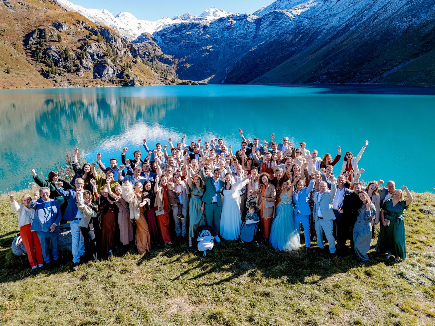 A group in coordinated outfits poses together on a scenic mountain deck during sunset.