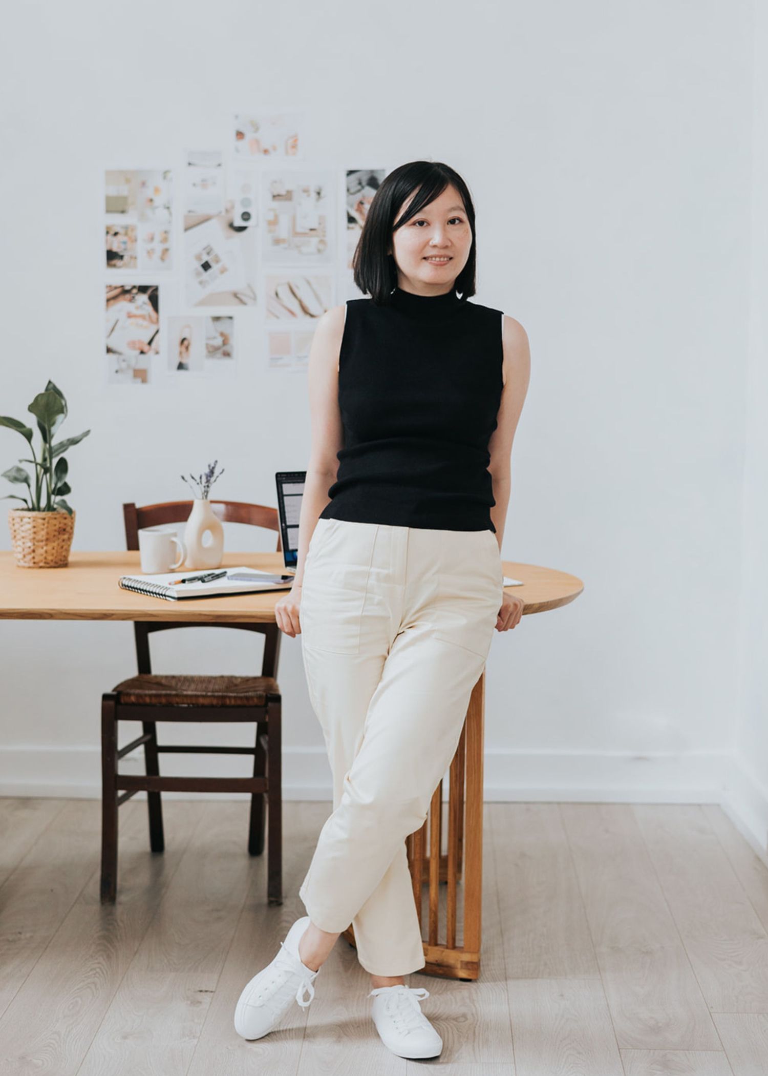 A minimalist lifestyle photo series showing someone in a black sleeveless top and white pants sitting in a modern workspace.