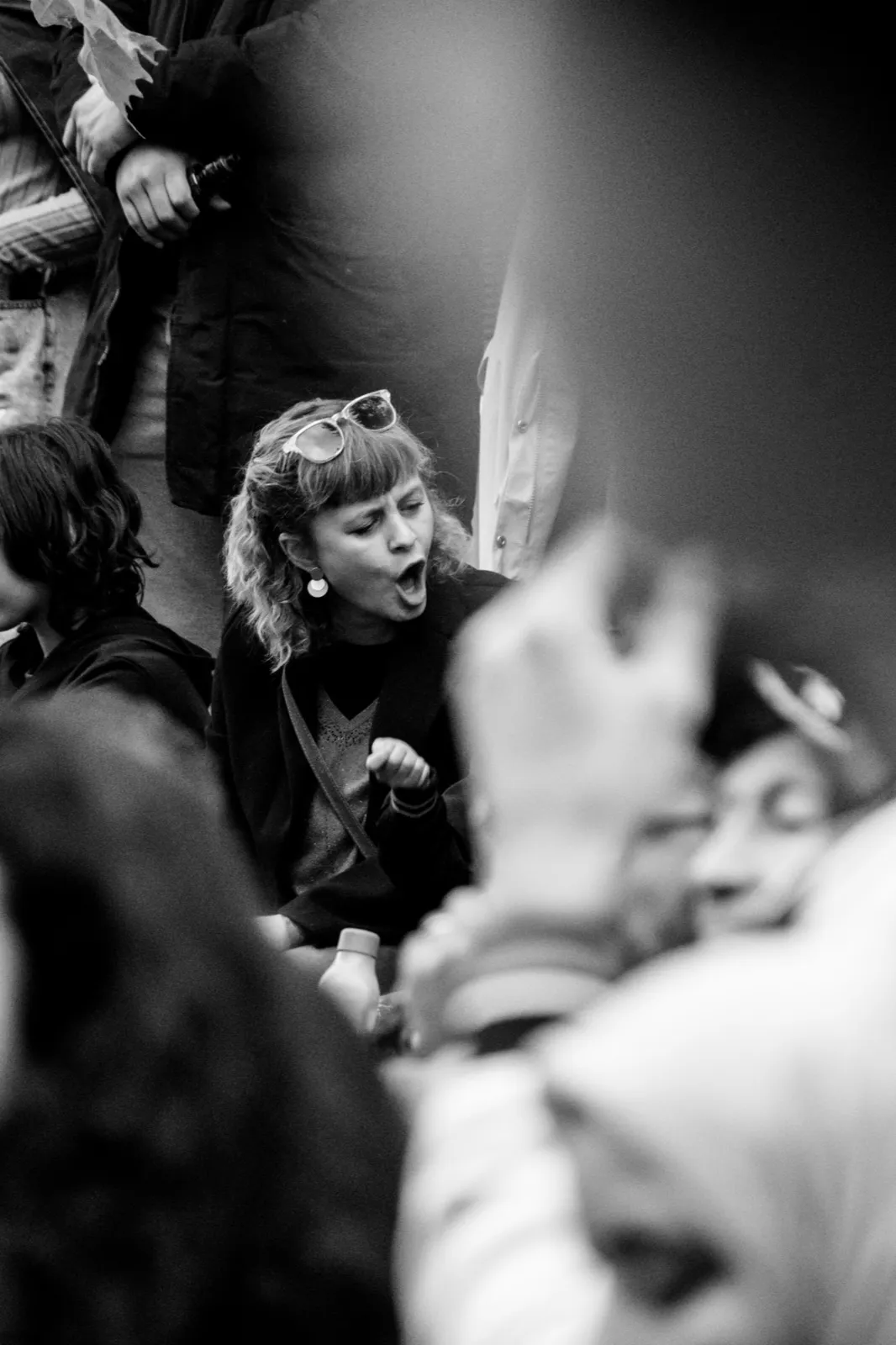 Visage d’un enfant dans la foule lors d’une manifestation, entouré de pancartes et de personnes engagées.
