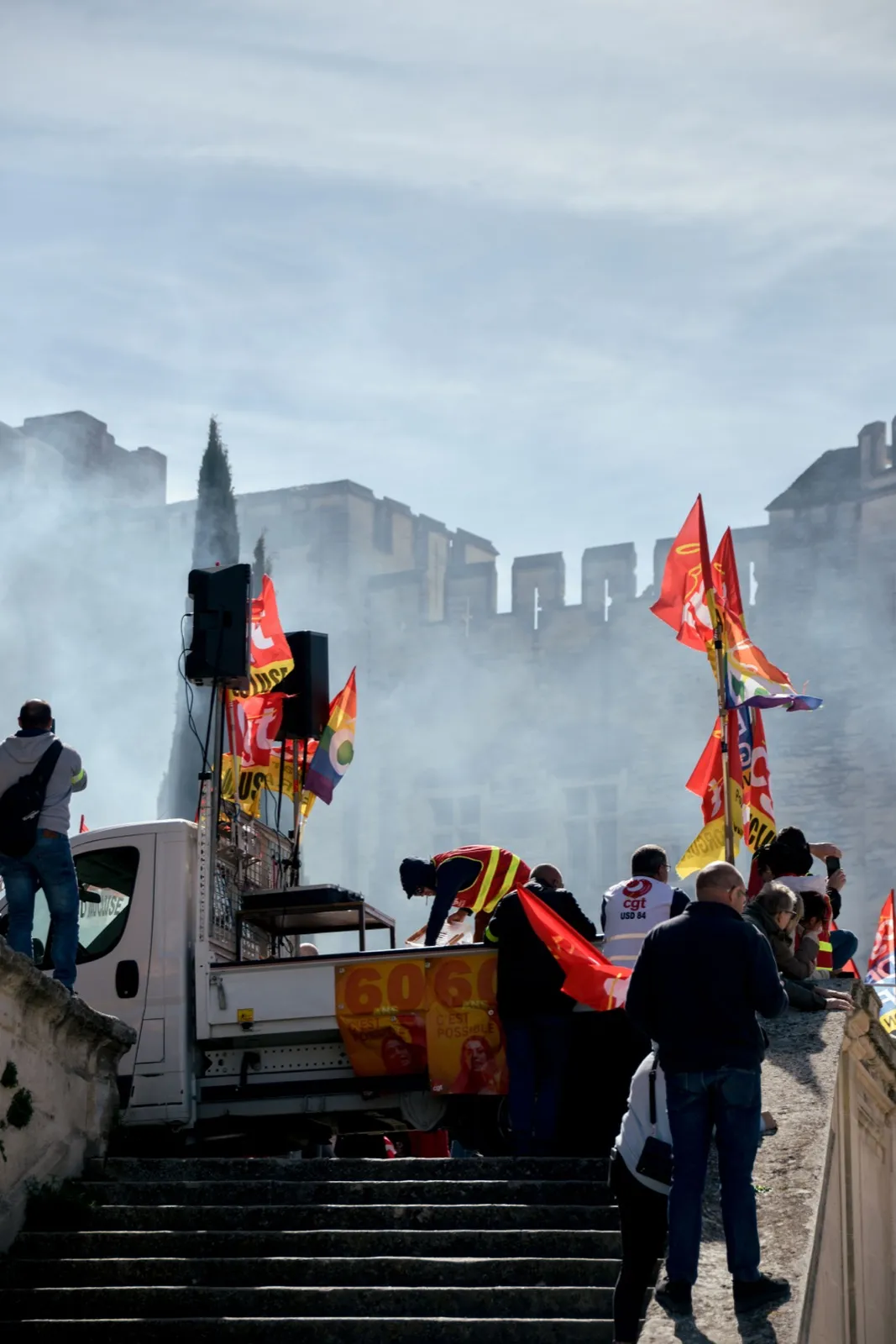 Personnes dans une manifestation portant des drapeaux.