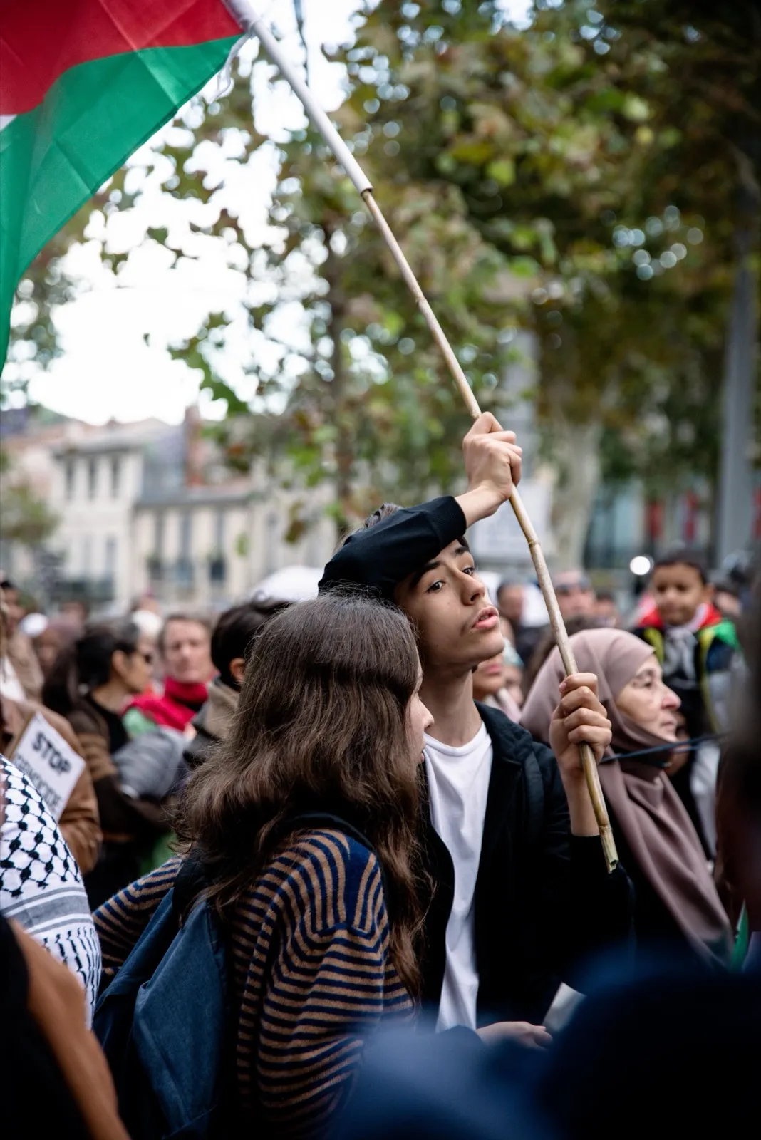 Personnes dans une manifestation portant des drapeaux.
