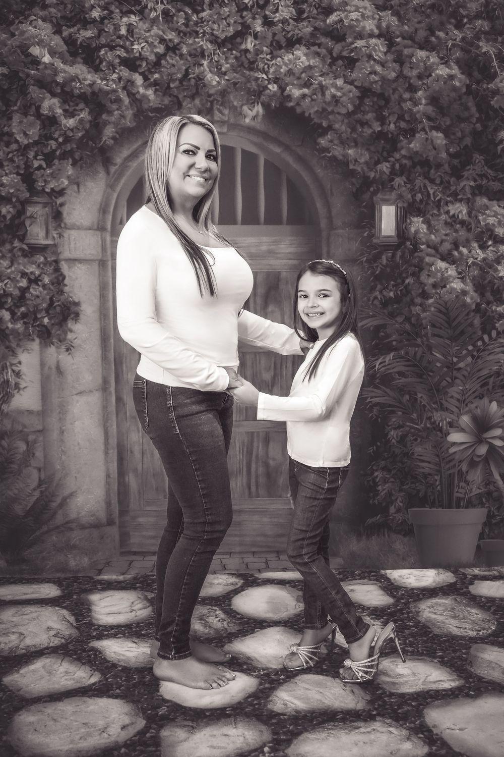 A series of black and white photographs showing a playful garden scene with two people enjoying time together on stone steps.