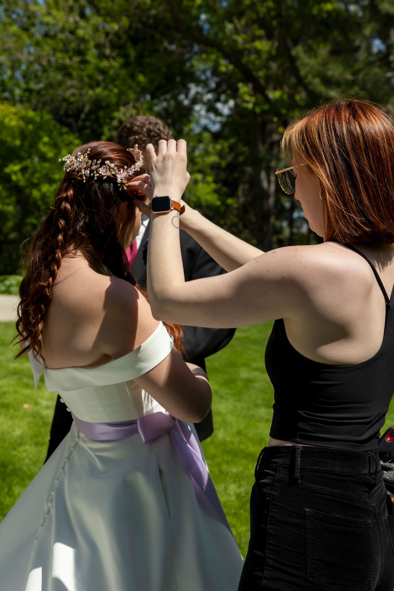Stylist fixing bride's hair before photos