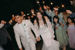 Newlyweds walking through sparklers during their wedding exit celebration.