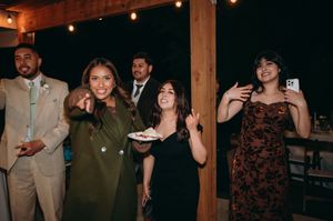 Wedding guests enjoying themselves at an outdoor reception under string lights.