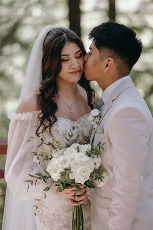 An intimate wedding moment shared between newlyweds with white roses.