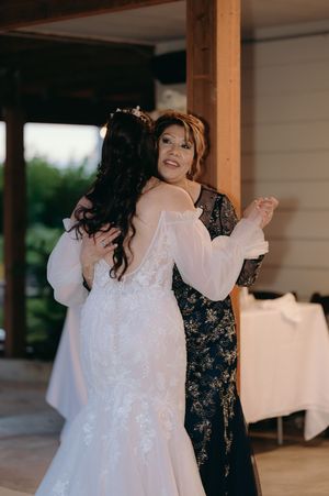Two women sharing an emotional moment at a wedding reception.