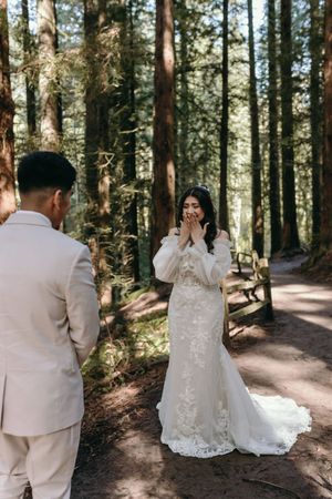 An emotional first look wedding moment on a forest trail.
