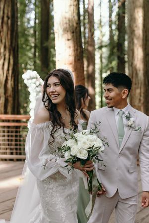 A joyful wedding moment captured in a redwood forest setting.