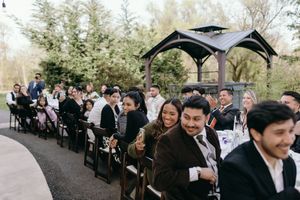 Wedding ceremony setup with rows of chairs under covered walkway outdoors.