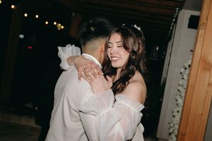 A romantic slow dance moment at an evening wedding reception under string lights.