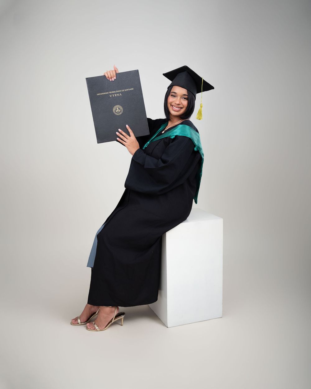 Sesión de fotos en estudio de graduación Utesa fondo blanco borla dorada República Dominicana