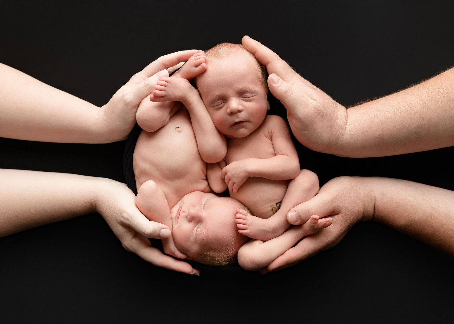 Twin newborn session snuggled together in mom and dad's hands. Greenville SC newborn photographer, Easley SC newborn photographer