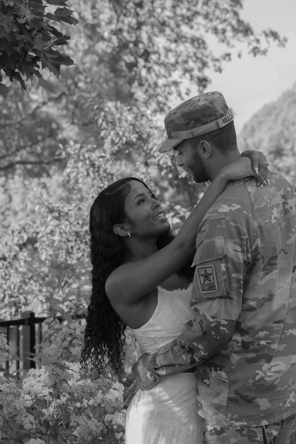 A romantic portrait of a couple sharing an intimate moment against a natural outdoor backdrop.