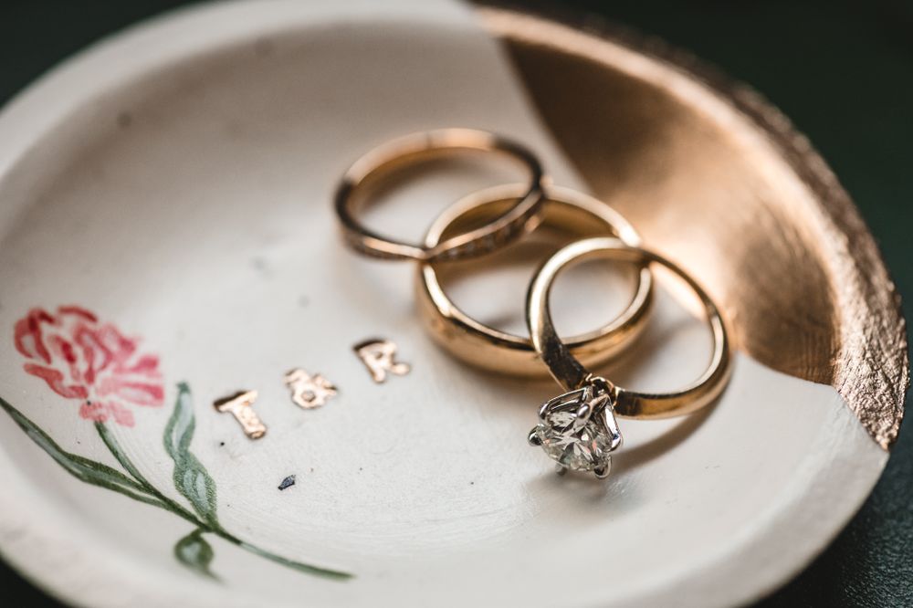 Wedding rings arranged on delicate floral-patterned china plate.