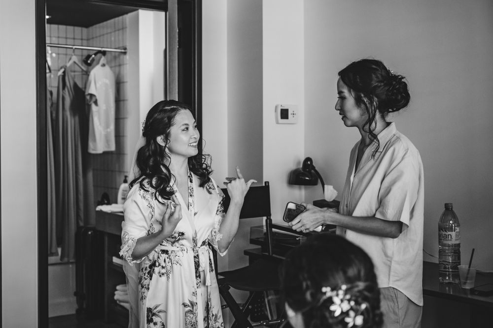 Black and white photo series showing wedding preparation moments in a hotel room.