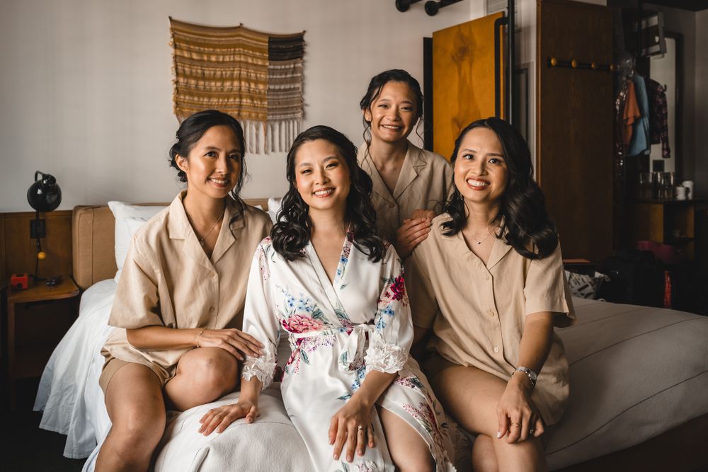 Wedding party relaxing together on couch during pre-ceremony preparations.