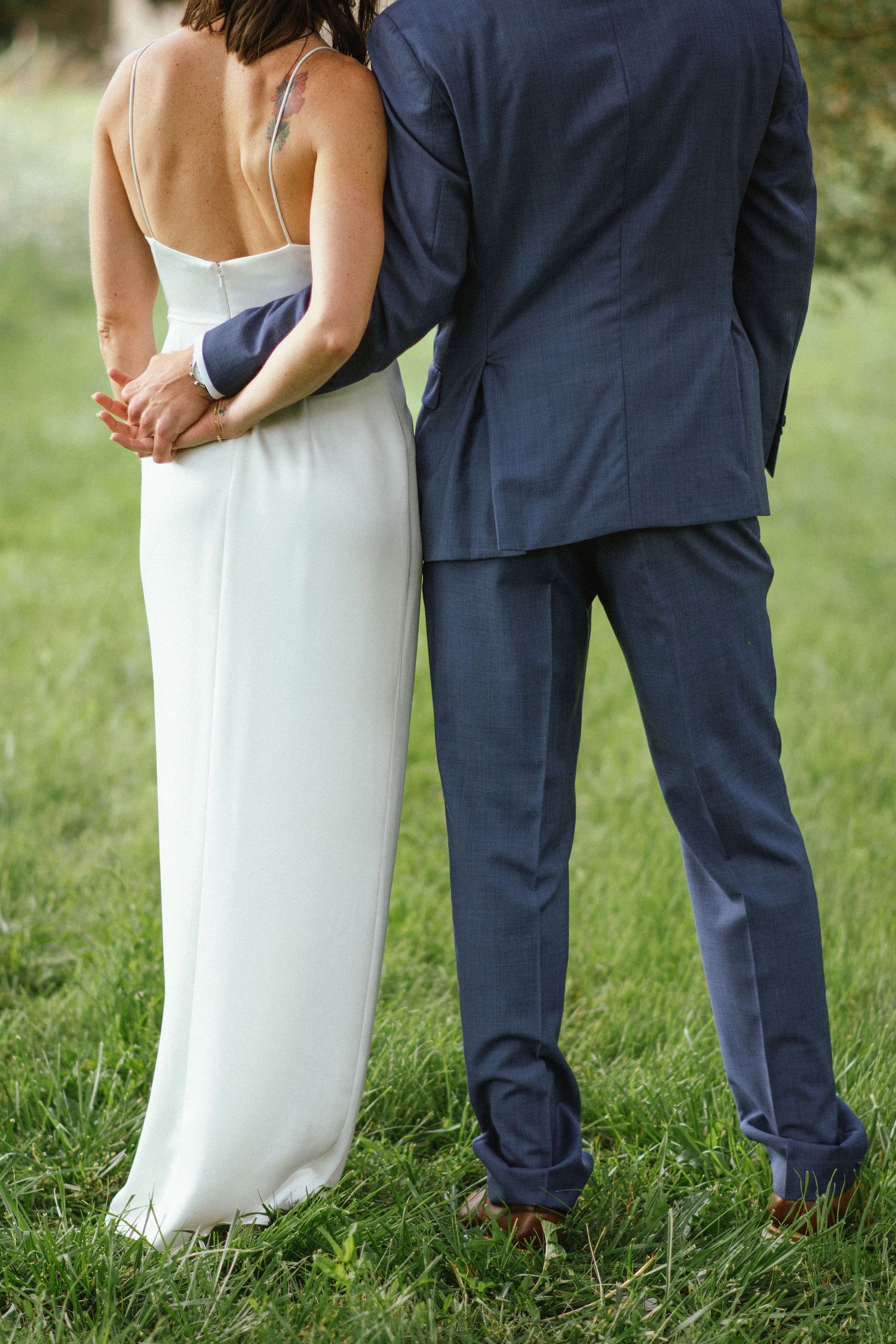 Gros plan sur le dos de la mariée et le bras du marié, élégance naturelle en Centre‑Val  de  Loire
