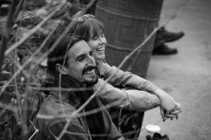 Black and white image of two people sharing a moment outdoors.