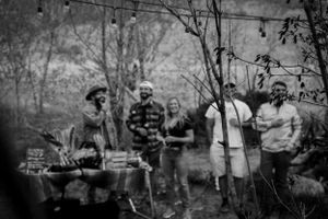 Musicians performing together outdoors with instruments in a casual setting.