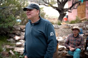 Two people in casual outdoor wear standing in a rustic setting.
