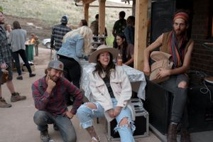 Group of people relaxing on a porch during an outdoor gathering.