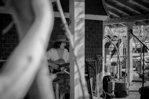 A musician performs on guitar in an artistic black and white composition.