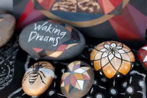 Painted rocks with spiritual designs including Waking Dreams text and mandala patterns.