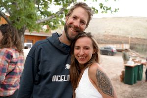 Casual outdoor portrait of two people standing together with desert landscape in background.