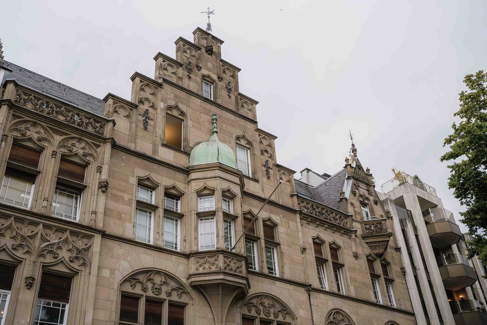 Gothic architectural details of a historic stone building with ornate windows and decorative elements.