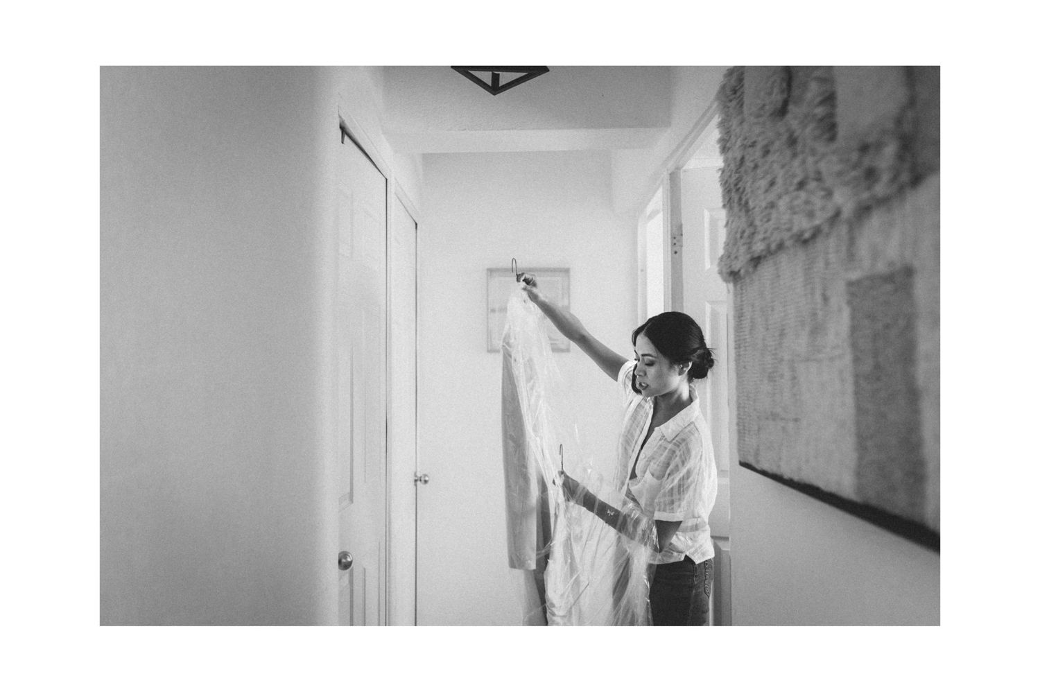 Three black and white surveillance camera footage stills showing movement in a dimly lit hallway.