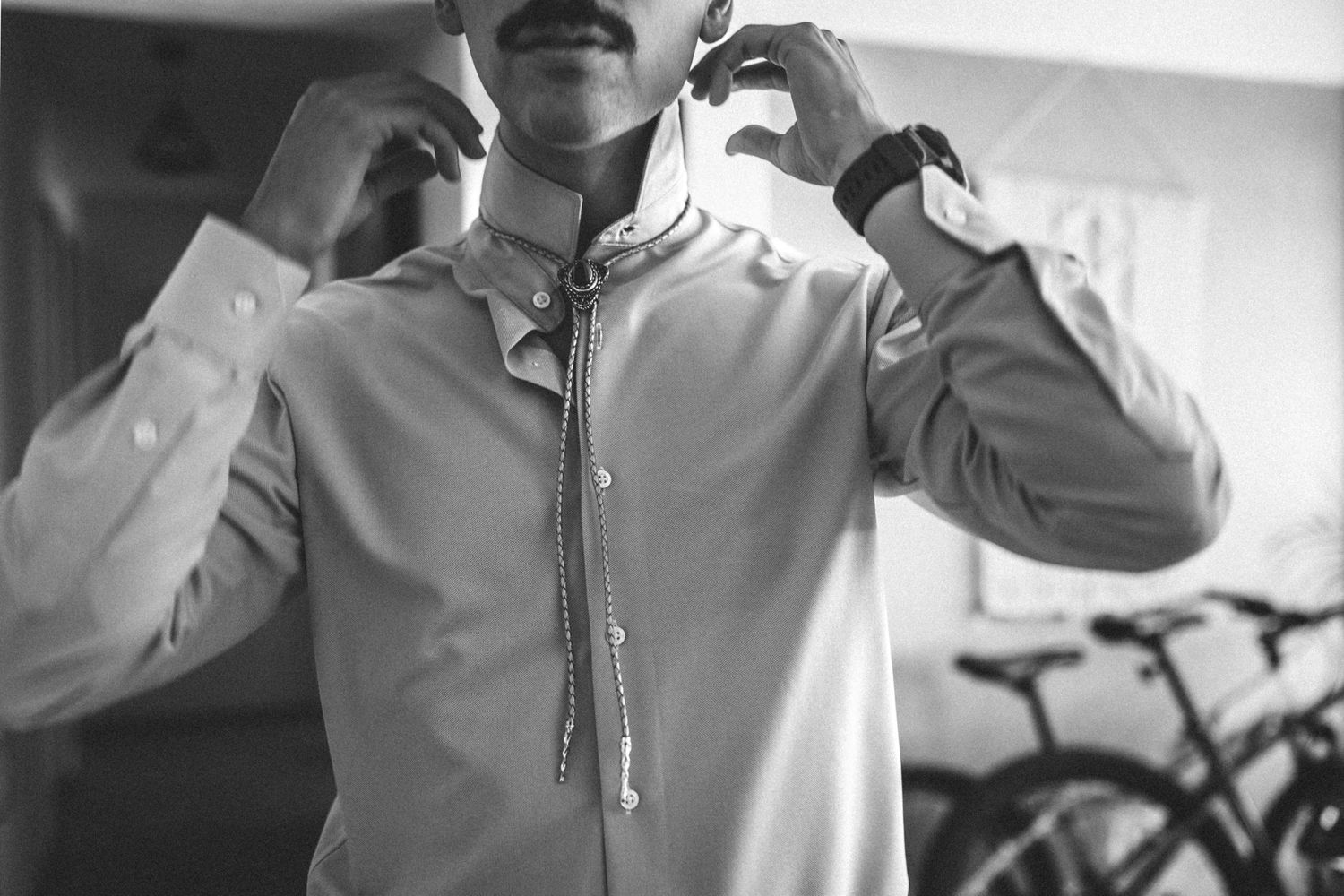 A person in white clothing practicing throwing darts with proper form and technique.