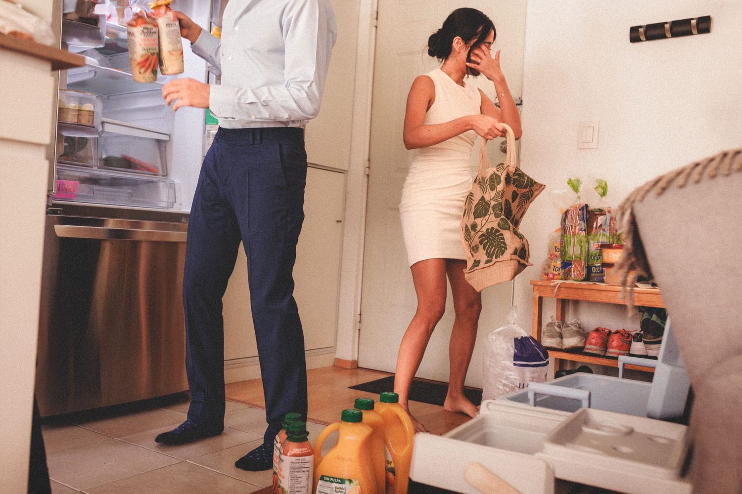 Several people gather in a casual indoor setting with white walls and furniture.