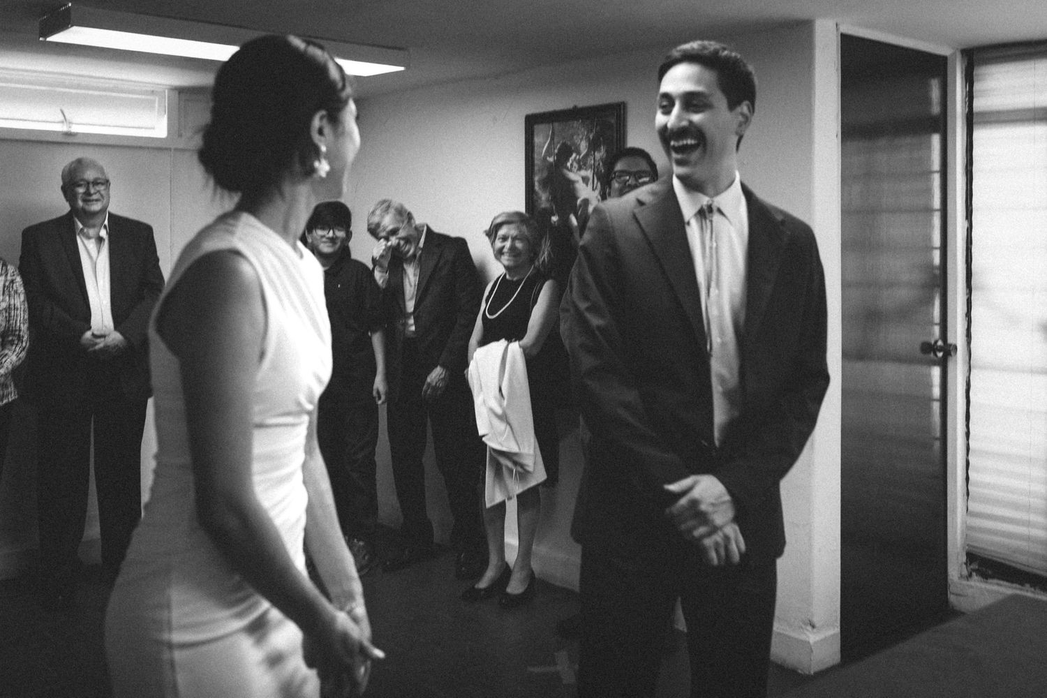 A candid black and white photo showing a joyful moment at a gathering.