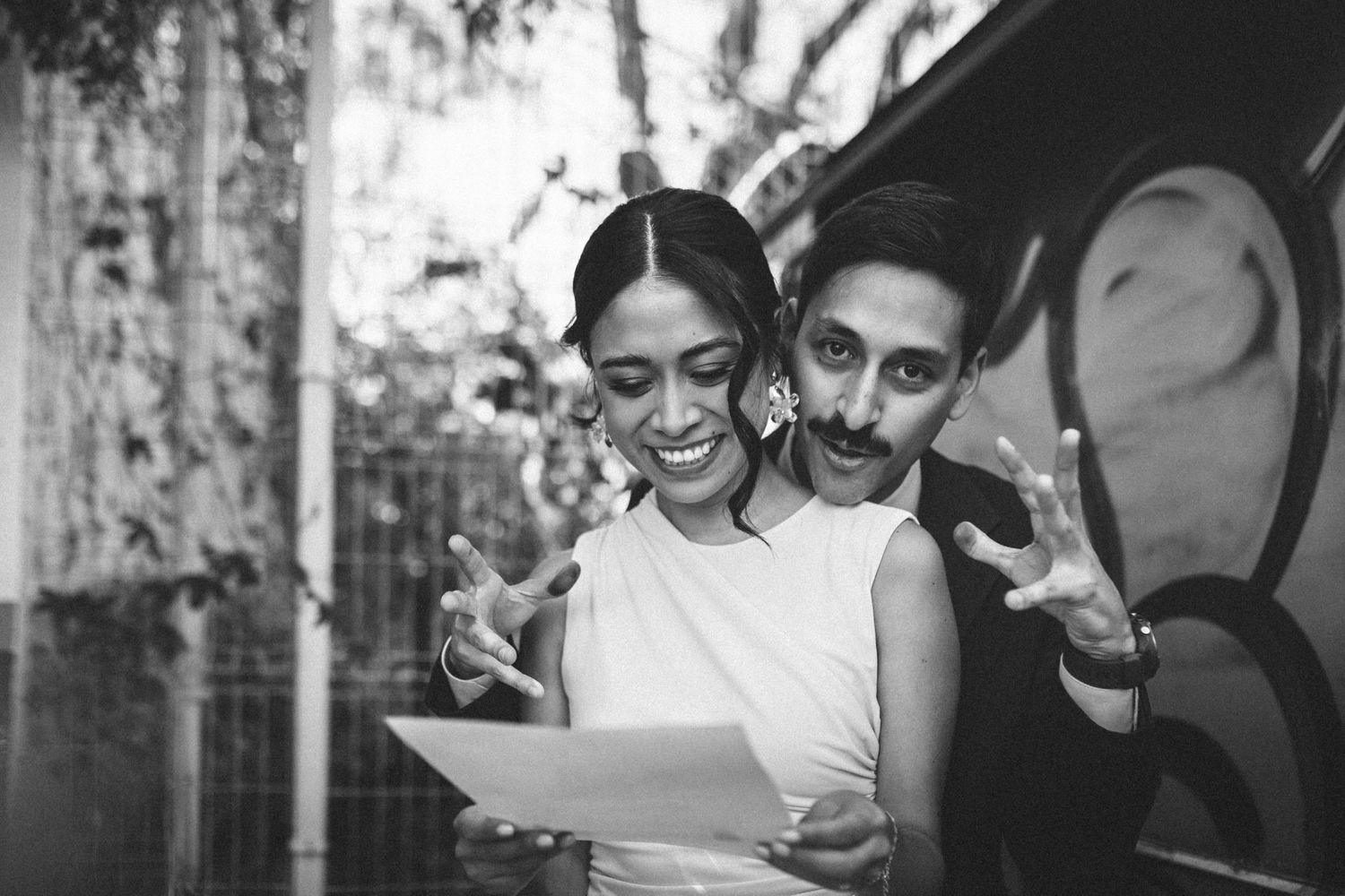 Candid black and white photo capturing natural expressions and laughter in an indoor group setting.