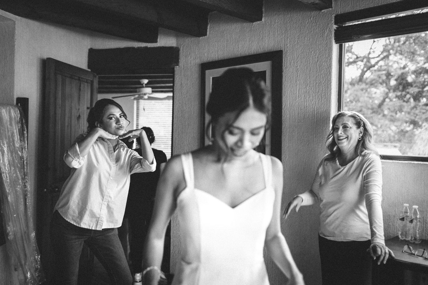 A series of black and white wedding preparation photographs showing bridal dress fittings and getting ready moments.