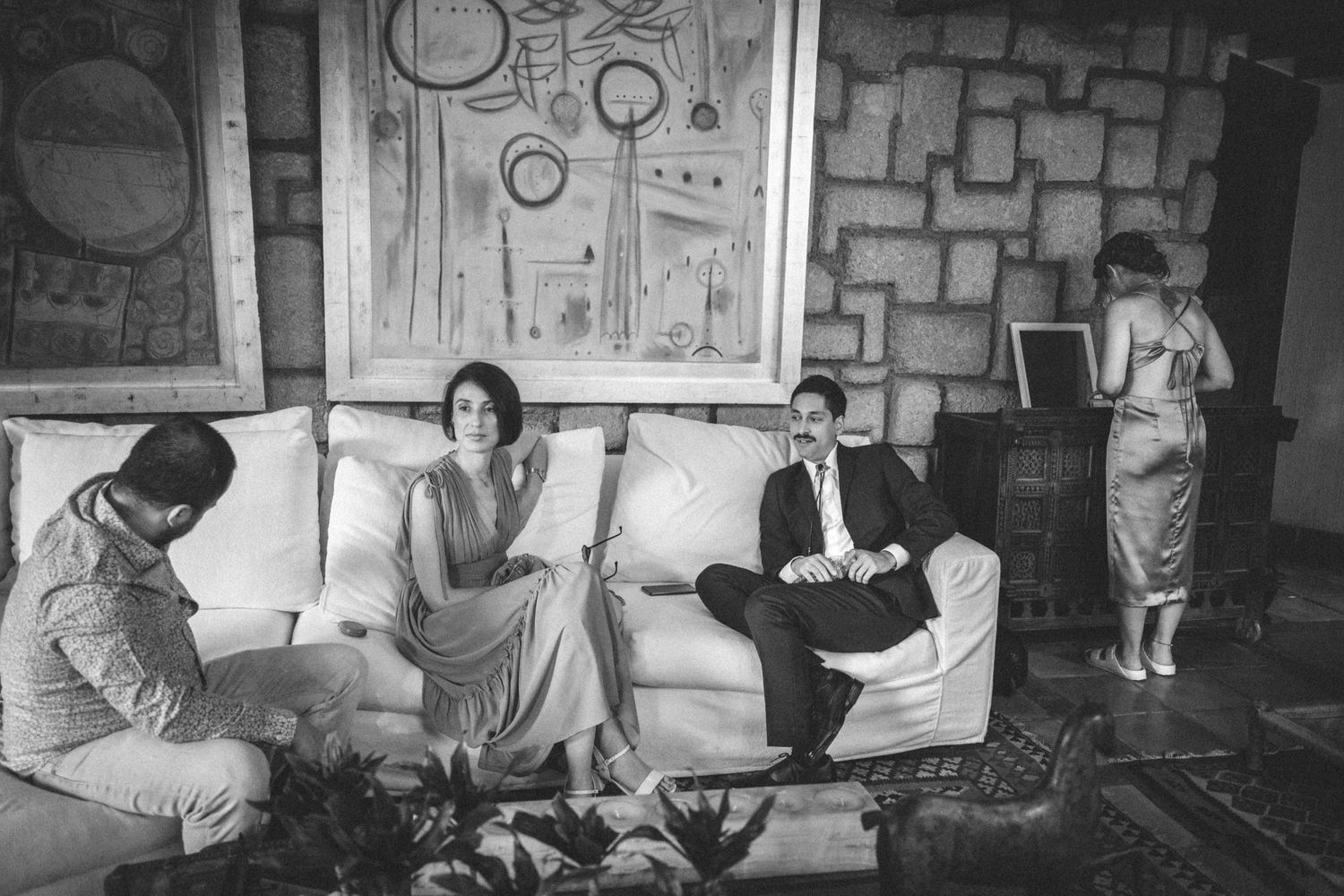 Black and white photos show a group relaxing in a rustic indoor stone-walled setting.