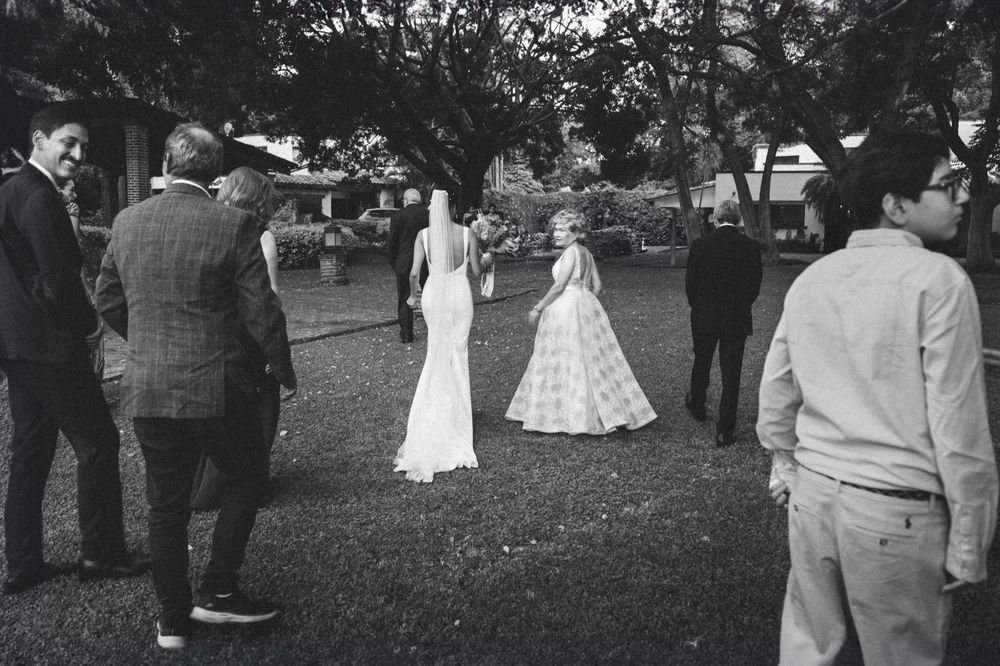Black and white panoramic photograph of guests gathered outdoors at a vintage social event.