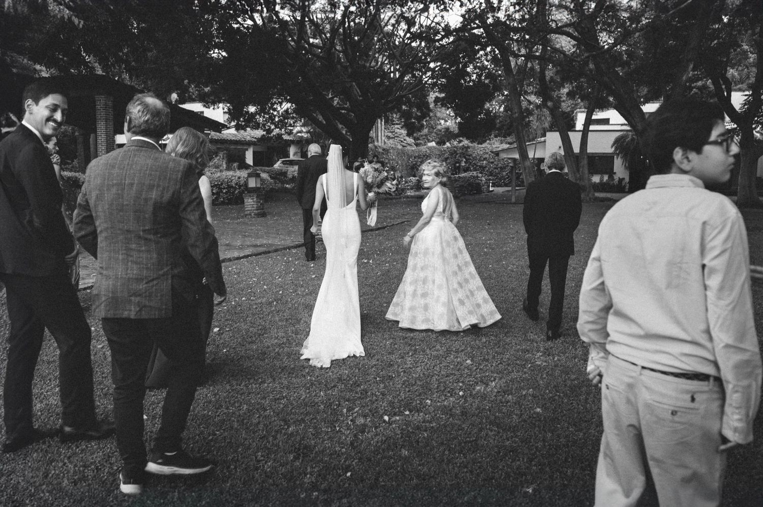 Black and white panoramic photograph of guests gathered outdoors at a vintage social event.