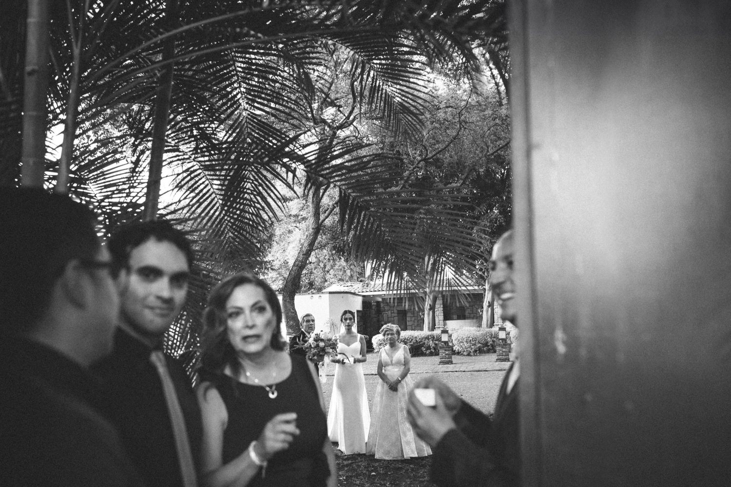 Black and white collage of candid moments from a wedding reception showing guests enjoying themselves in low lighting.