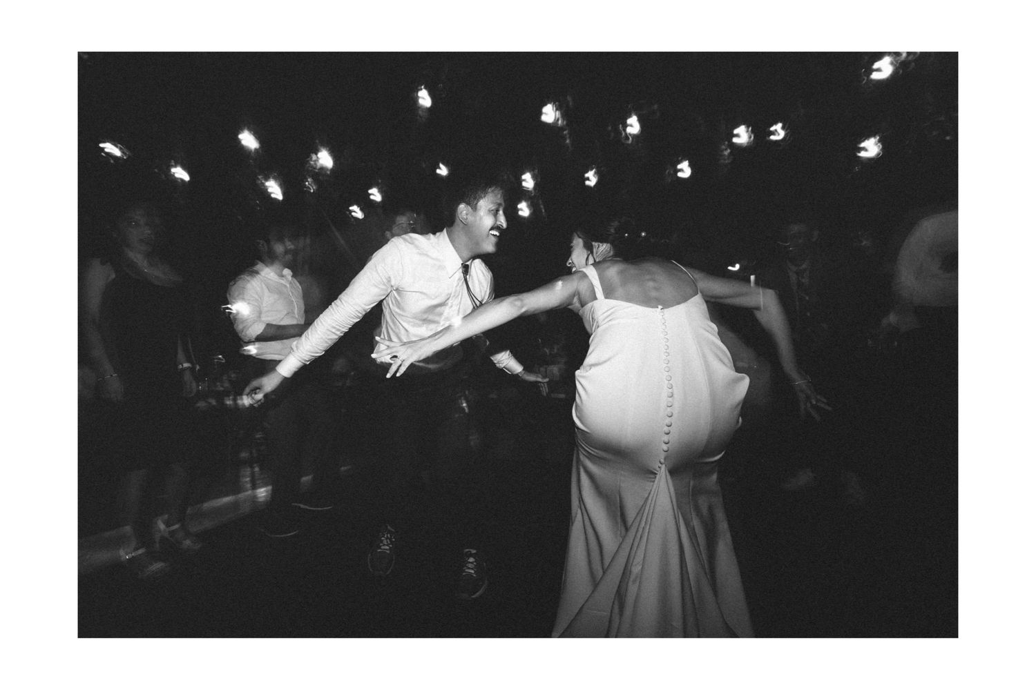 Black and white photograph shows energetic dancing at what appears to be a crowded nightclub or party.