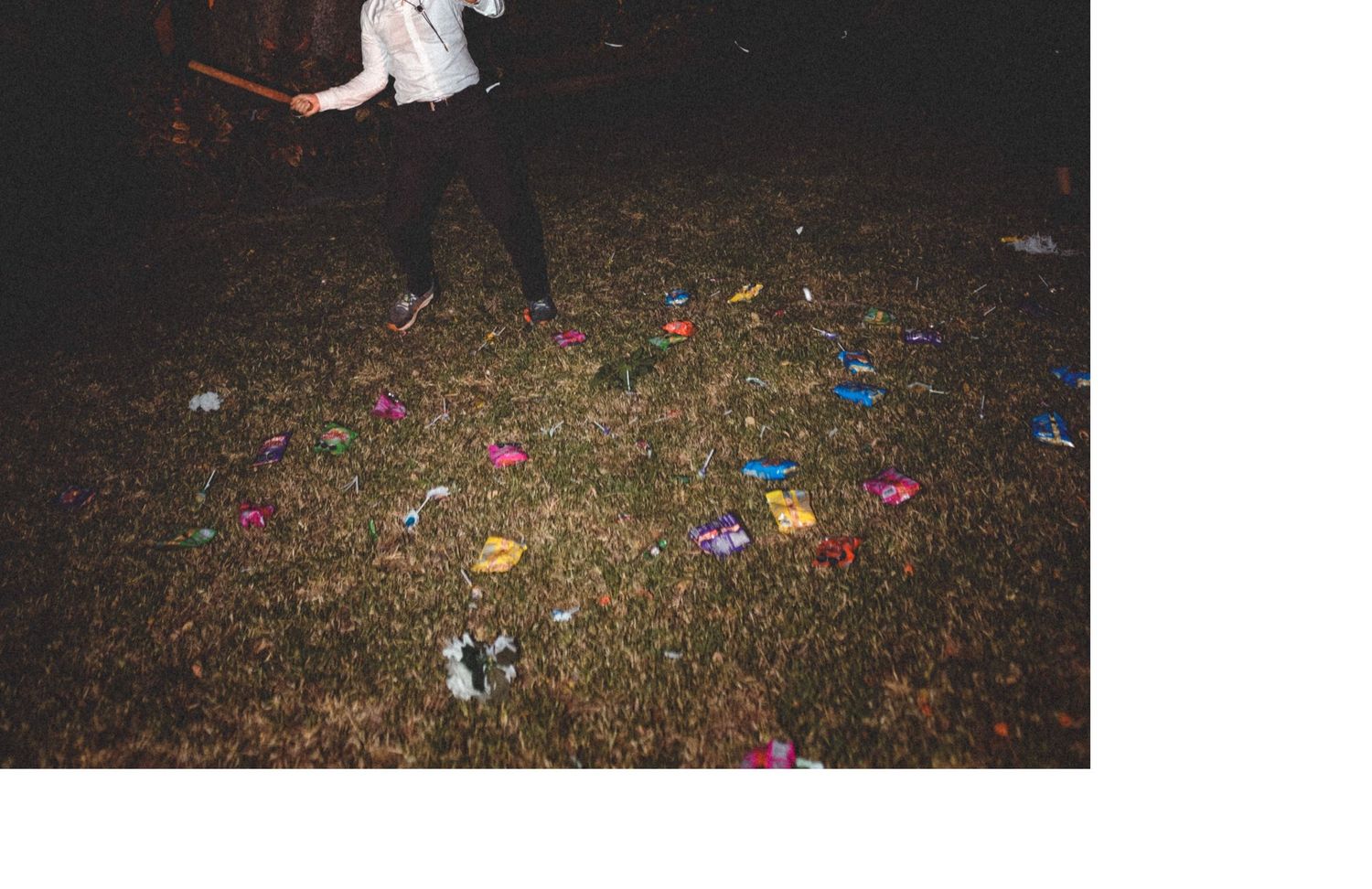Scattered confetti and streamers decorate the darkened ground during a festival aftermath.