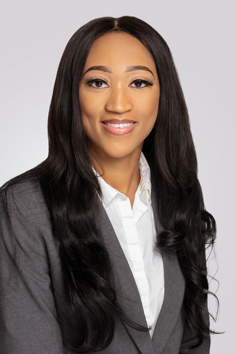 Professional portrait of woman in gray suit and white shirt with long straight hair.