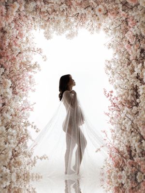 A dreamy artistic photo series showing a figure in white amidst ethereal pink cherry blossoms and soft lighting.