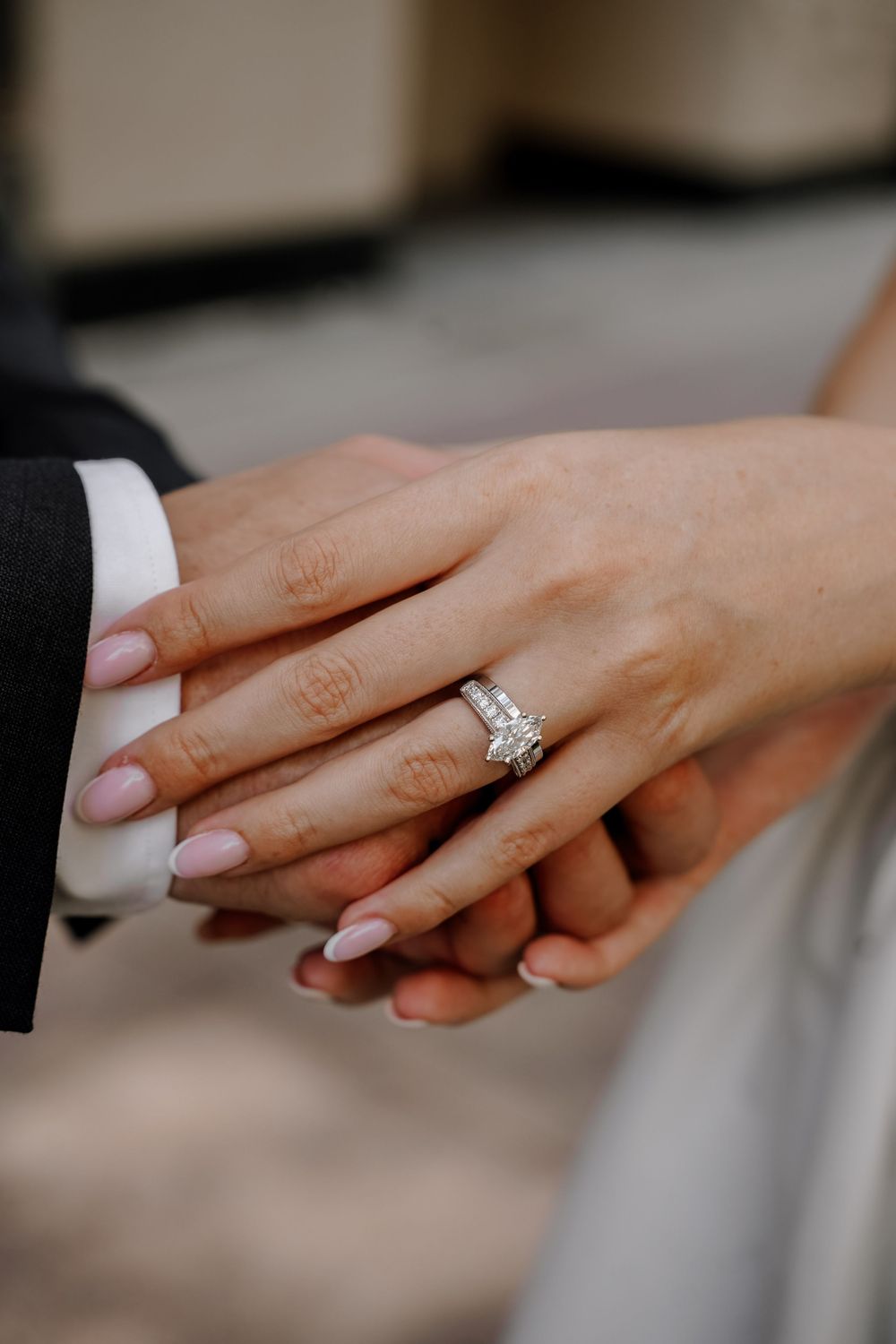Close-up photos showing a sparkling diamond engagement ring in various angles on a hand with neutral manicure.