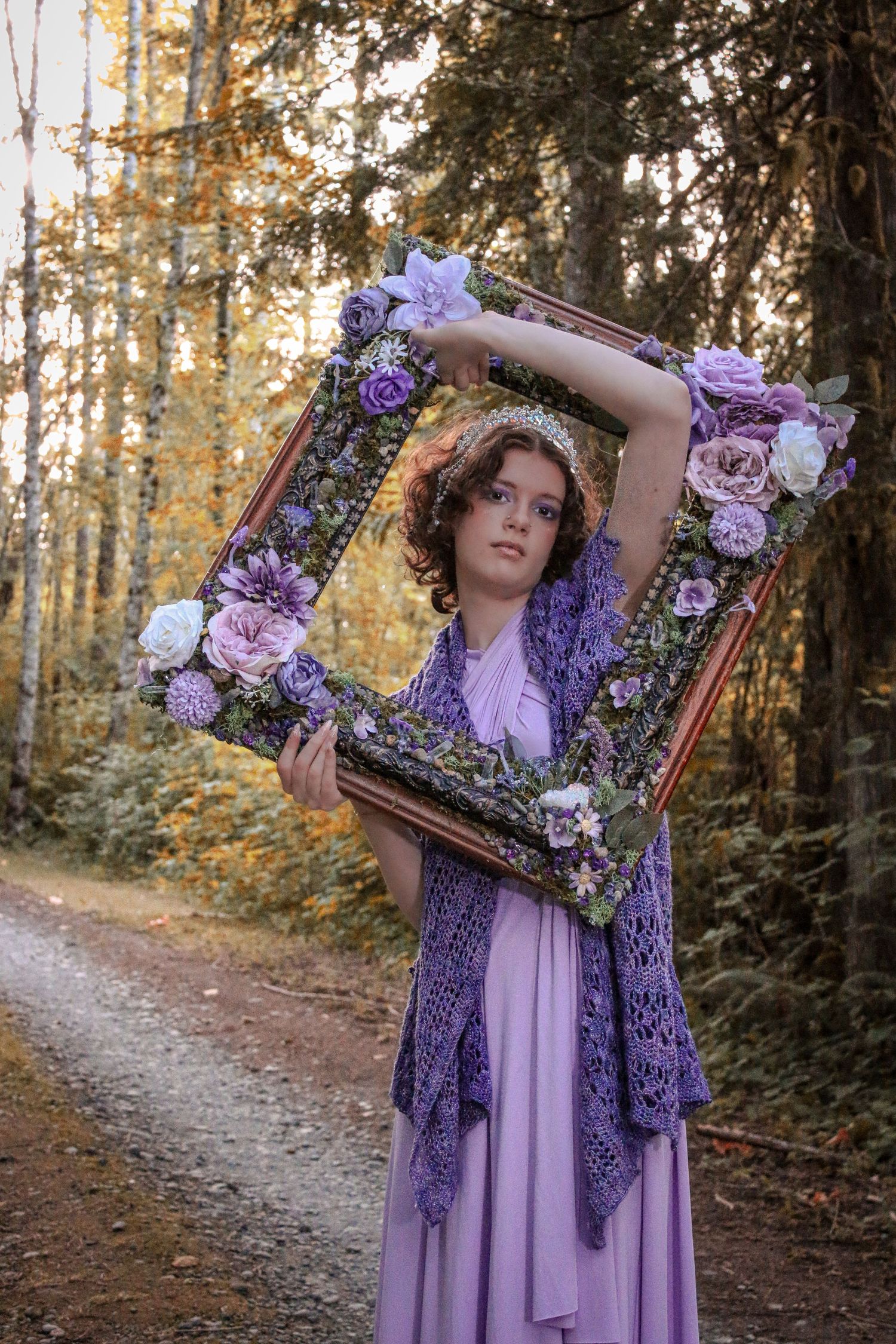 A romantic forest scene with an ornate floral frame and a flowing purple dress against an autumn woodland background.