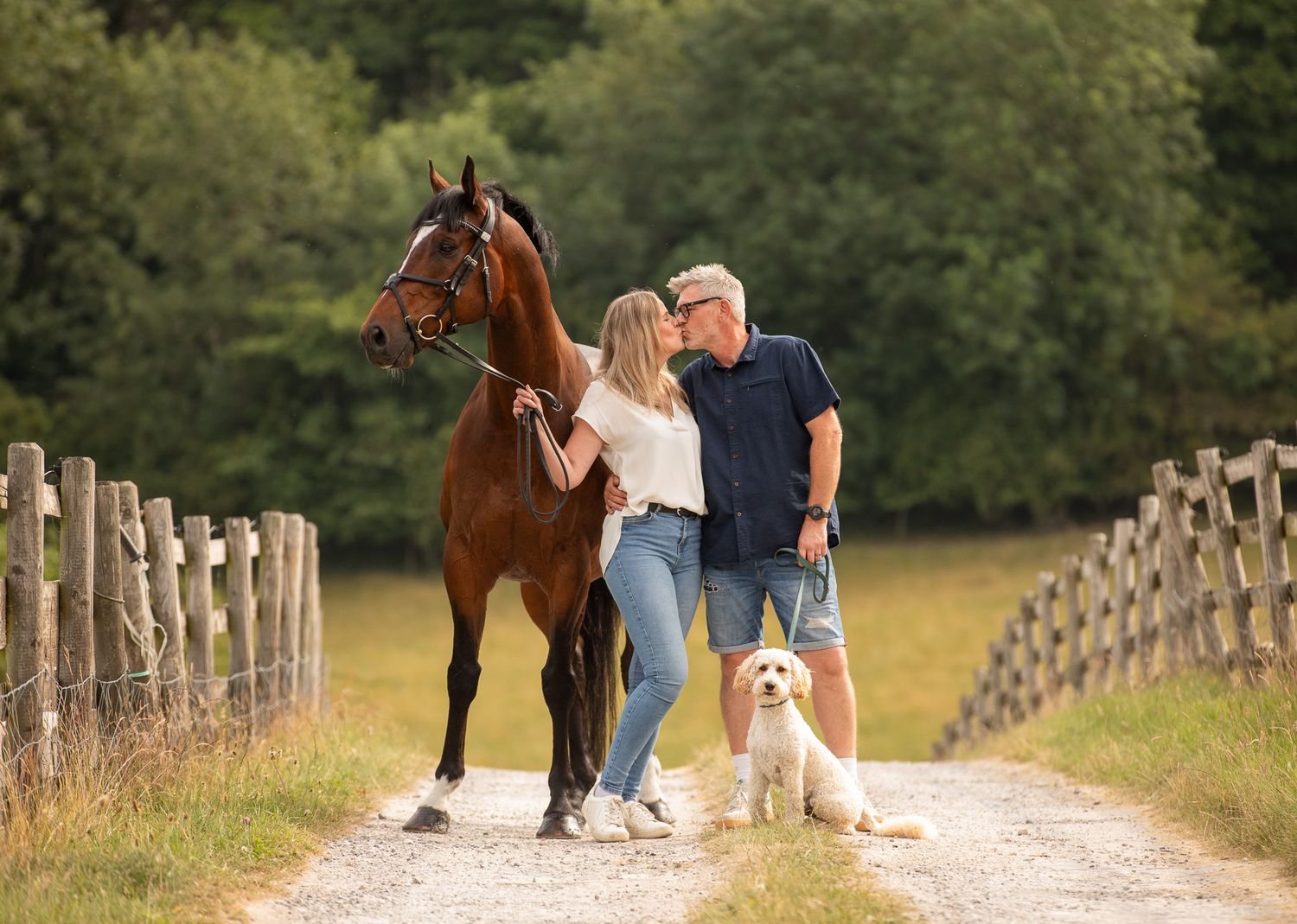 A brown horse and person stand together in a woodland clearing filled with blooming bluebells.