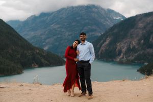 Couple posing at Diablo Lake overlook with turquoise water and mountain backdrop in North Cascades, Washington.