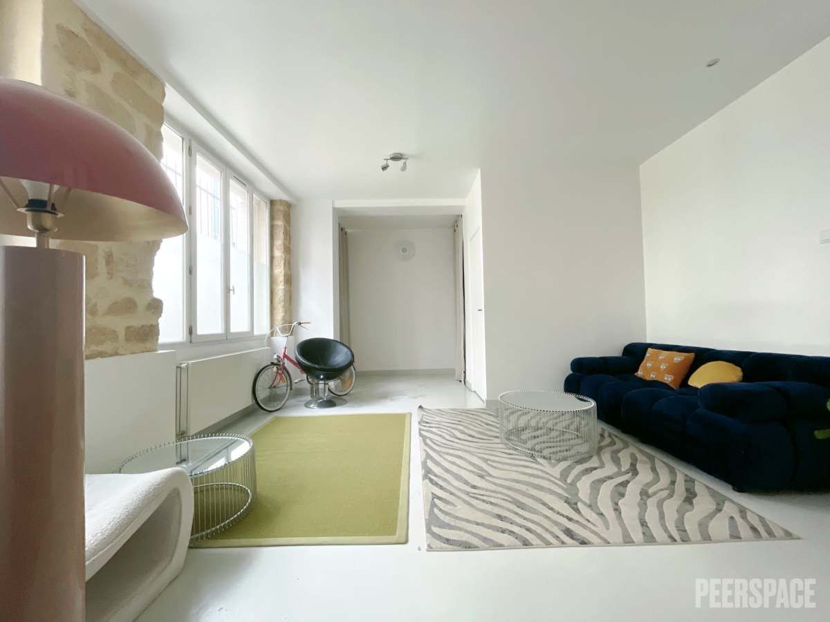 Portrait professionnel d’un praticien bien-être dans un studio chaleureux au design naturel, avec murs olive clair, matériaux authentiques