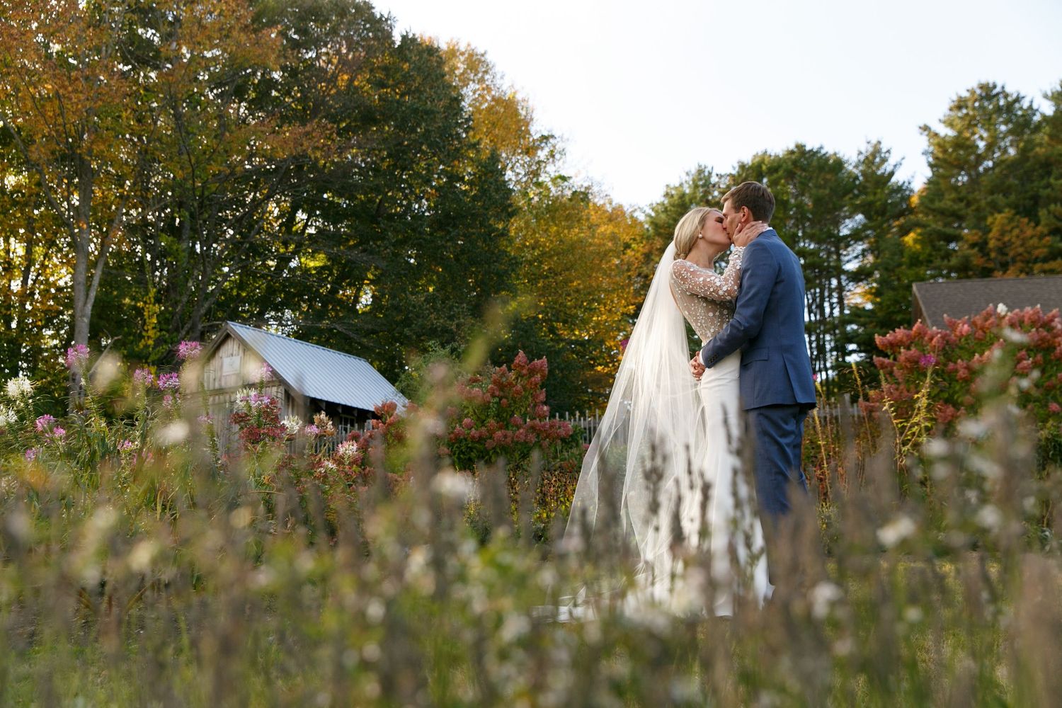 Fall wedding photography in field with autumn foliage and golden light.